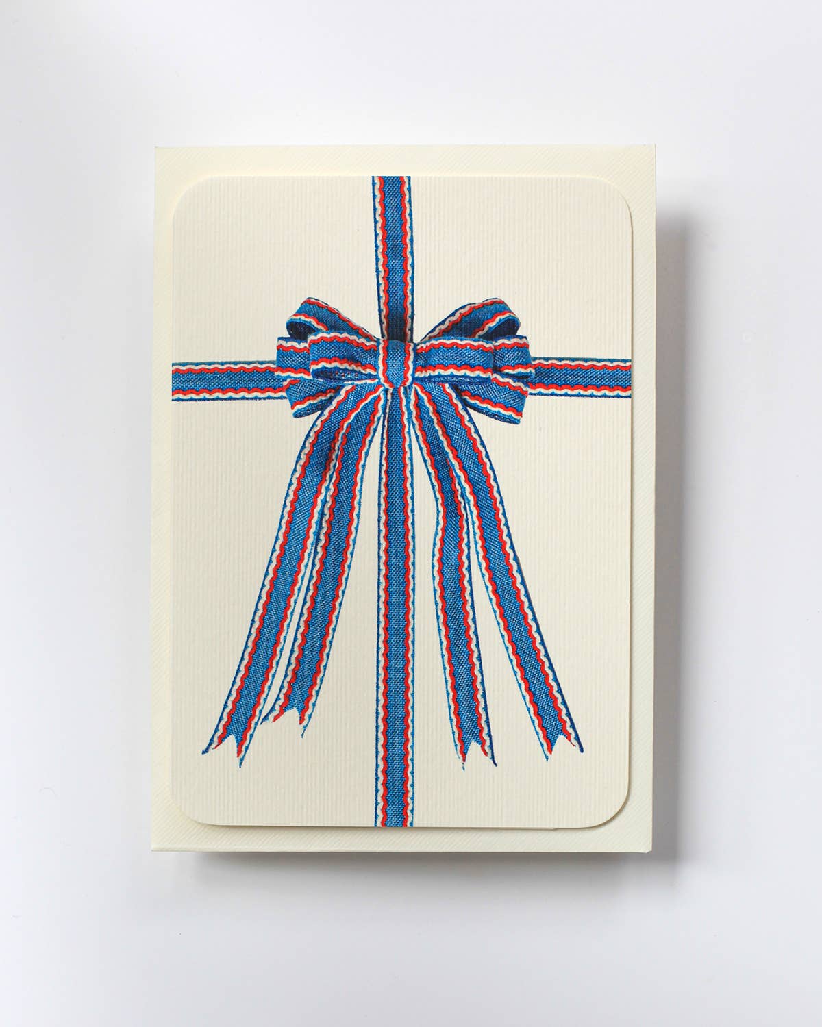 Biglietto d'auguri con fiocco blu, rosso e bianco