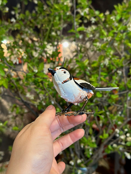 Uccello marrone e bianco in metallo riciclato