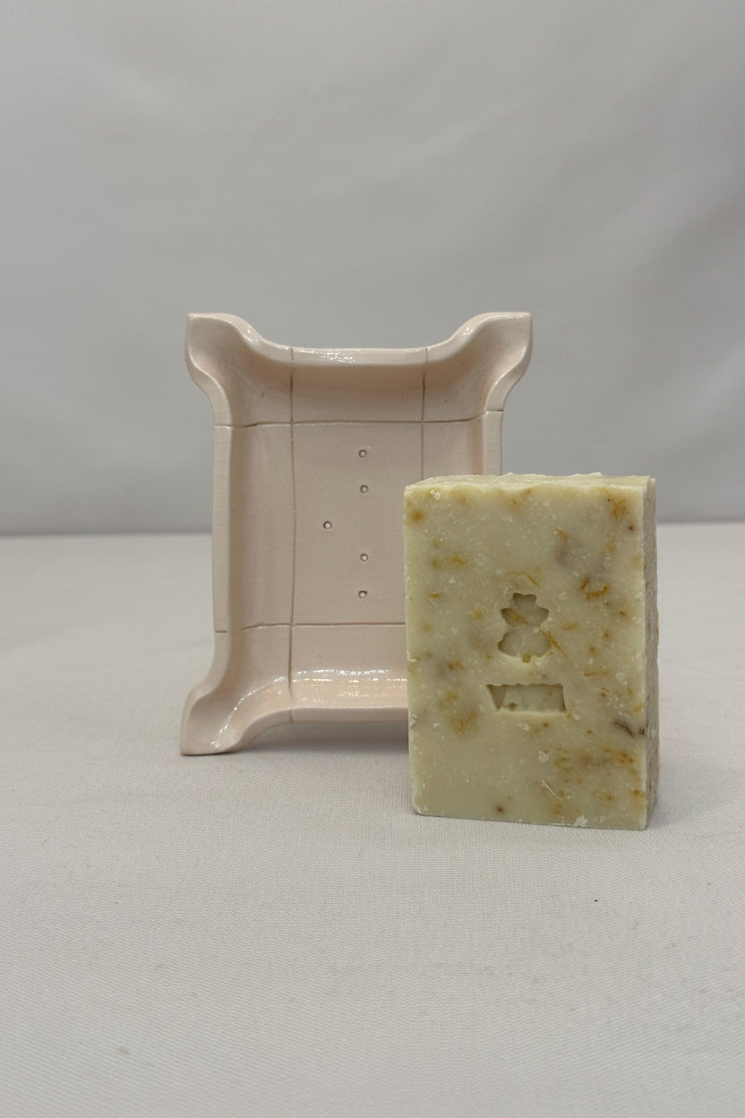 Bar of soap with a decorative stand on a neutral background